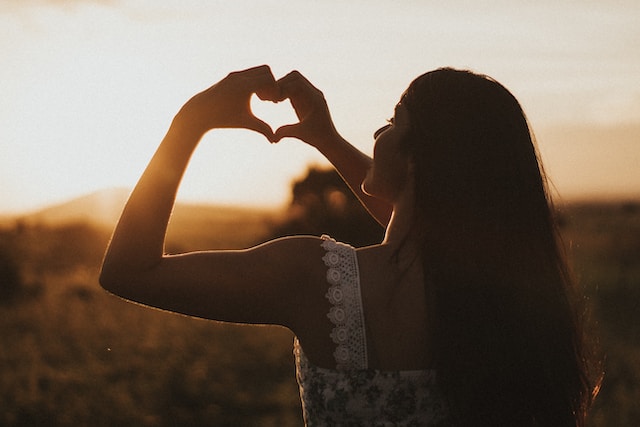 woman forms heart with two hands