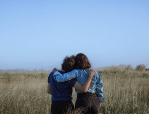 Friends embracing in a spacious meadow