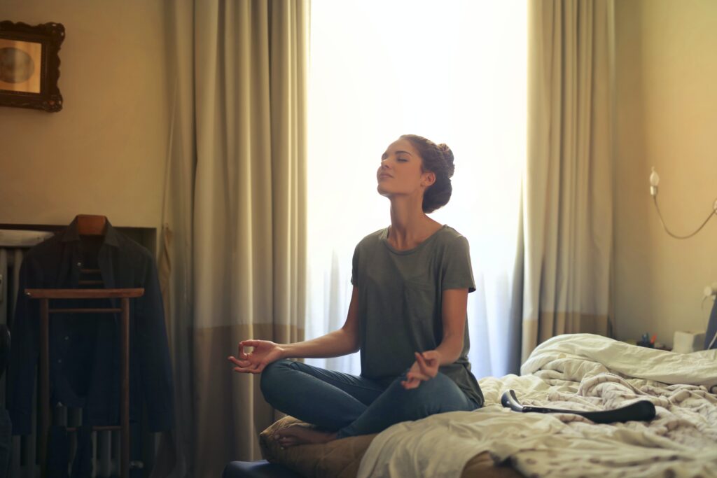 Woman meditating in a bedroom