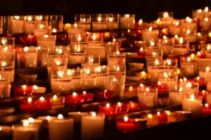 Rows of lit candles in the darkness