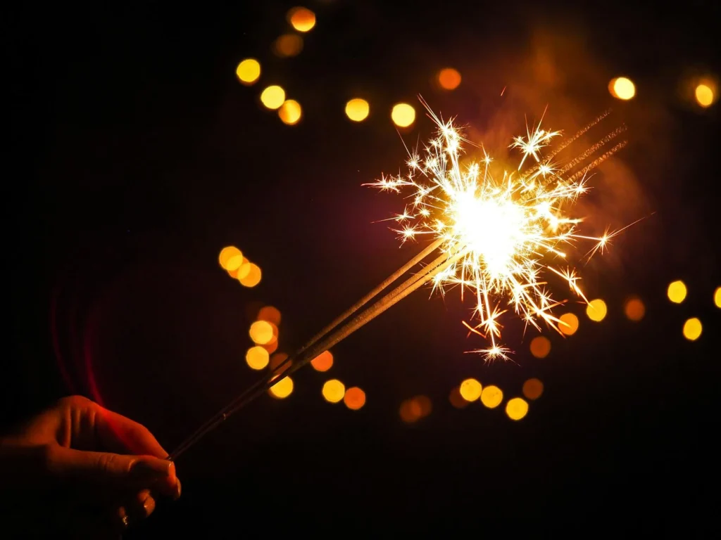 A hand holds a lit sparkler.