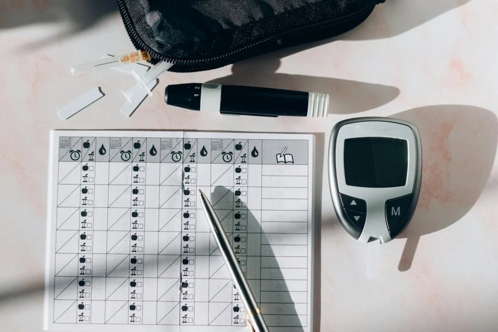 A tracker for multiple habits with a scale, pen and marker beside the notepad.